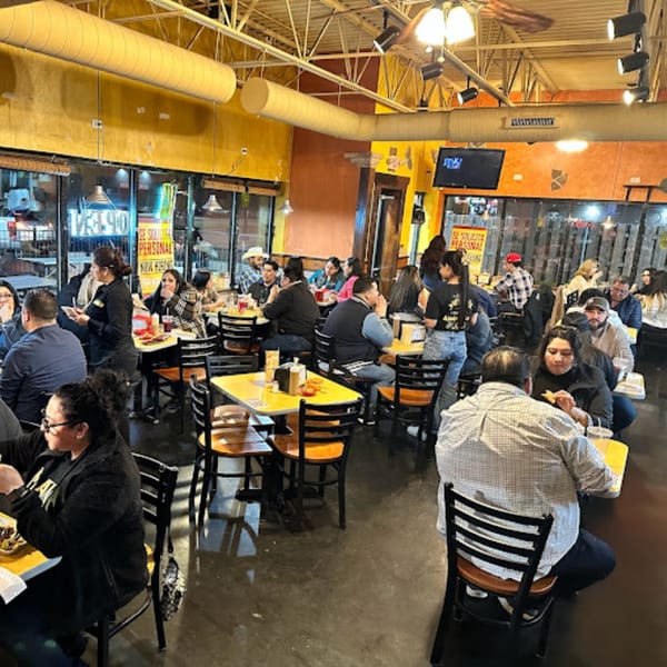 Diners fill the vibrant, casual interior of Taquerias Atotonilco, enjoying Mexican food at tables.