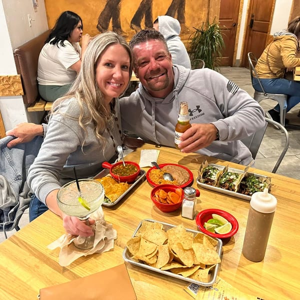 Smiling couple enjoying Mexican food and drinks at Taquerias Atotonilco.
