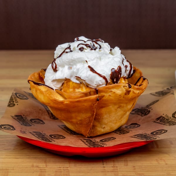 Fried ice cream in a crispy tortilla bowl, topped with whipped cream and chocolate syrup.